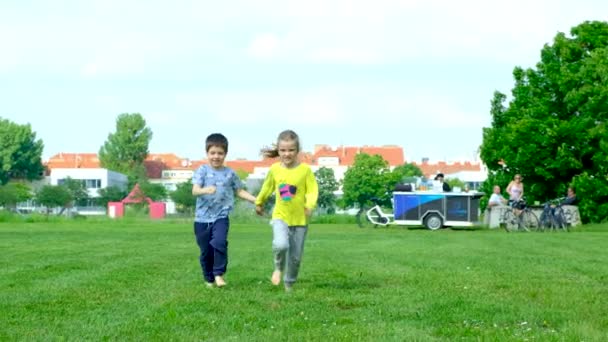 소년과 소녀는 잔디에 맨발을 실행합니다 아이들의 우정과 행복한 시절의 — 비디오