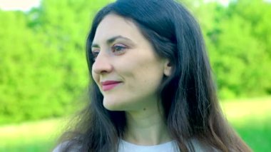 35 yaşında esmer bir kadın başını kameraya çevirip gülümsüyor..