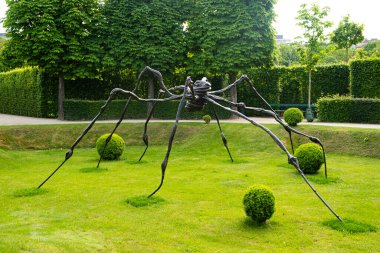 Parktaki dev bir siyah metal örümceğin heykeli. Çağdaş sıradışı sanat.