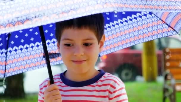 Ένα Εξάχρονο Αγοράκι Στέκεται Έξω Κάτω Από Μια Ομπρέλα Καλοκαίρι — Αρχείο Βίντεο