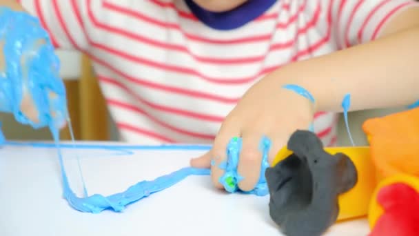 Ein Sechsjähriger Junge Spielt Mit Schleim Während Hause Einem Tisch — Stockvideo