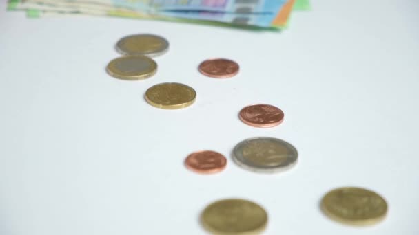 一个女人坐在白桌边数着欧元 钞票和硬币 — 图库视频影像