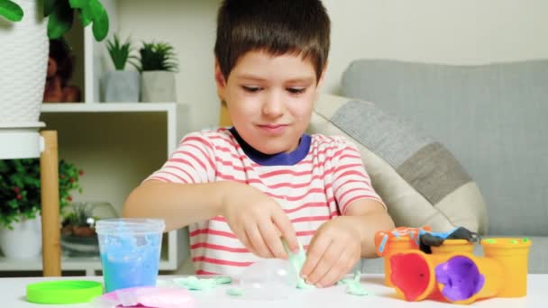 Sexårig Pojke Leker Med Slem När Han Sitter Vid Ett — Stockvideo