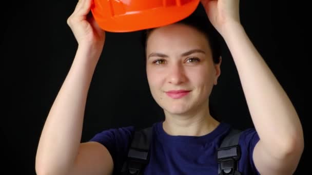 Eine Ingenieurin Oder Bauarbeiterin Trägt Einen Schutzhelm Auf Schwarzem Hintergrund — Stockvideo