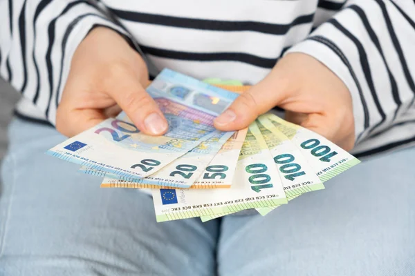 Different denominations of euro banknotes in the hands of a person, twenty, fifty and one hundred euros