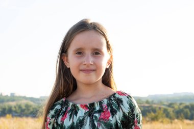 Doğada yazın tarlada yürüyen mutlu beş yaşındaki bir kızın portresi.