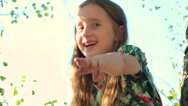Ridendo Bambina Puntando Dito Avanti Fotocamera Mentre Seduto Albero Estate — Video Stock