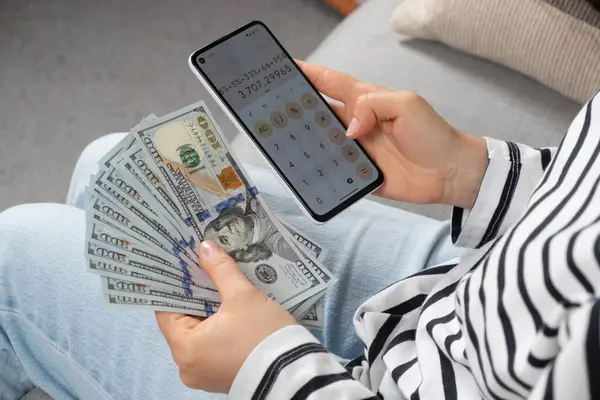 一百元钞票和智能手机在一个人手里 — 图库照片