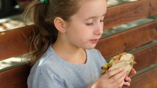 Burger Yiyen Küçük Bir Kız Açık Bir Bankta Oturuyor Sokak — Stok video