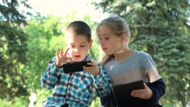 Gyerekek Használni Szerkentyű Miközben Parkban Szabadban Játékok Okostelefon Tabletta — Stock videók