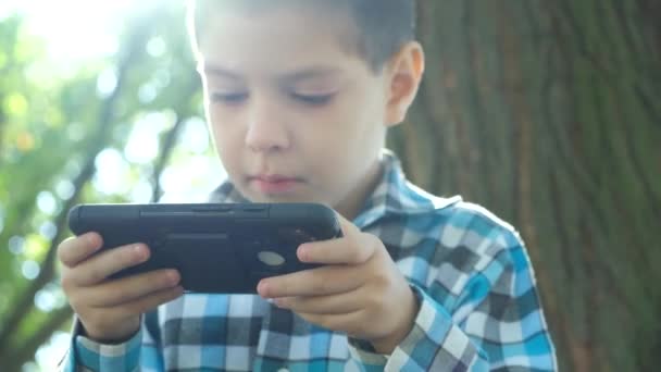 Garotinho Jogando Jogo Smartphone Enquanto Estava Sentado Parque Natureza Verão — Vídeo de Stock
