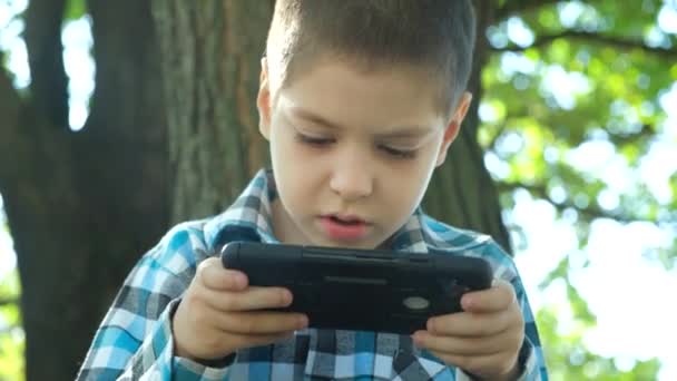 Garotinho Jogando Jogo Smartphone Enquanto Estava Sentado Parque Natureza Verão — Vídeo de Stock
