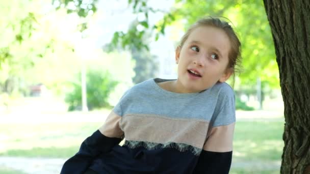 自然の中で公園でリラックスしながら話しているかわいい5歳の女の子 — ストック動画