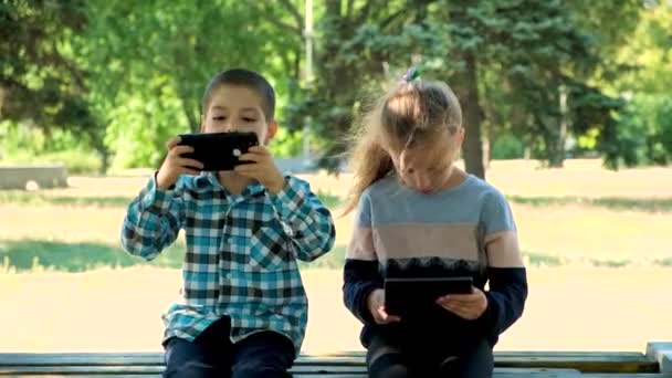 Crianças Usam Gadgets Enquanto Estão Sentadas Parque Livre Jogos Smartphones — Vídeo de Stock