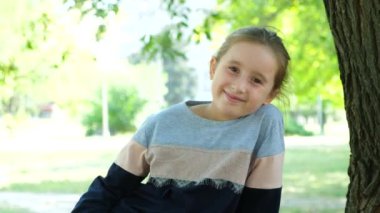 Parkta gülümseyen beş yaşındaki güzel Avrupalı bir kızın portresi..