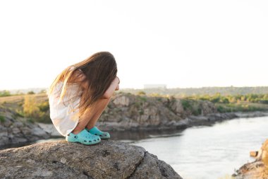 Doğada sadece kayaların üzerinde oturan beş yaşındaki üzgün kızı gücendirdim.