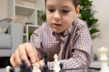 Küçük çocuk satranç oynuyor. Çocuklar için masa oyunları.