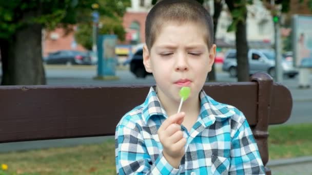 Een Kleine Jongen Knabbelt Een Lolly Schade Van Harde Snoepjes — Stockvideo