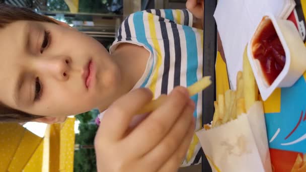 Pojke Äter Pommes Frites Mcdonalds Medan Han Sitter Vid Ett — Stockvideo