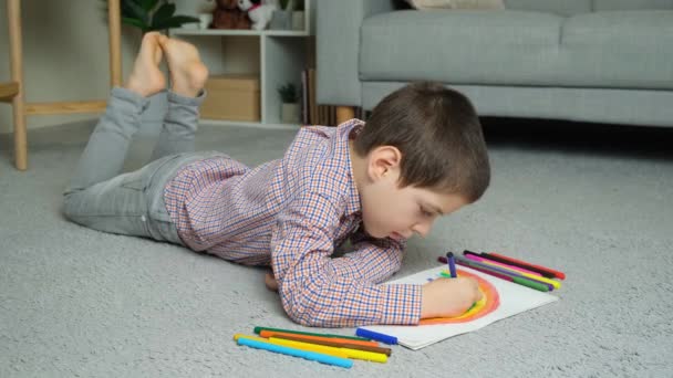 Băiețel Desenează Curcubeu Stilouri Într Carte Schițe Timp Află Covorul — Videoclip de stoc