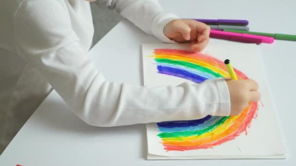 Bambino Piccolo Disegna Arcobaleno Con Pennarelli Quaderno Mentre Siede Tavolo — Video Stock