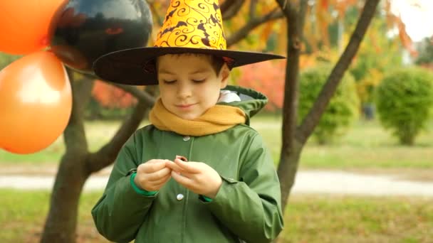 Happy Halloween Little Boy Opens Candy Outdoors — Stock Video