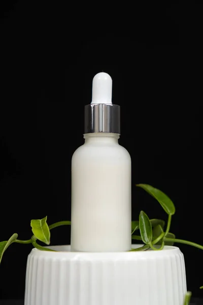 Natural herbal eco cosmetics - cream or serum in a glass jar with a pipette dispenser.