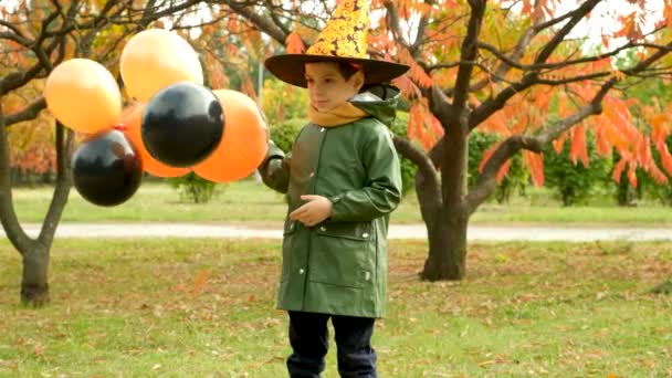 Sorglig Halloween Liten Pojke Leker Med Ballonger Utomhus — Stockvideo