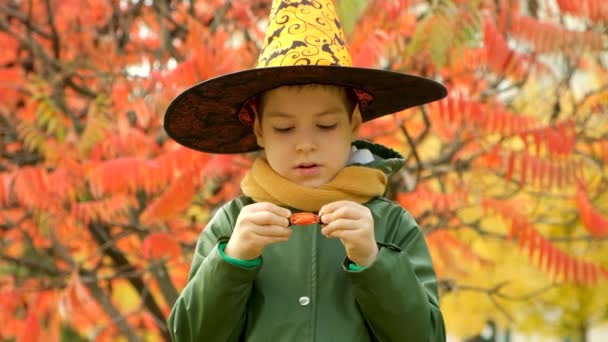 Glad Halloween Liten Pojke Öppnar Godis Utomhus — Stockvideo