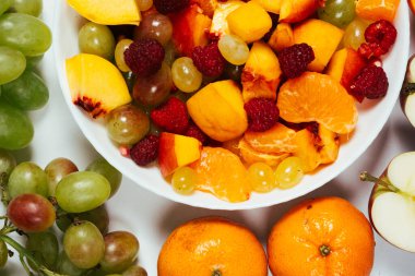 Dilimlenmiş meyve salatası, karışık üzüm, ahududu, nektarin, mandalina ve elma..