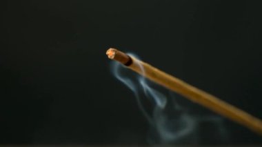 Siyah arka planda yanan bir aroma çubuğundan çıkan duman. Tütsü çubukları, aromaterapi ve meditasyon