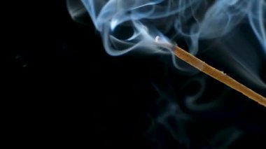 Siyah arka planda yanan bir aroma çubuğundan çıkan duman. Tütsü çubukları, aromaterapi ve meditasyon