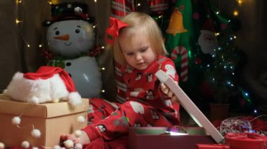 Küçük tatlı kız Noel hediyelerini açıyor..