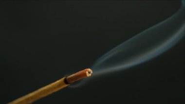 Siyah arka planda yanan bir aroma çubuğundan çıkan duman. Tütsü çubukları, aromaterapi ve meditasyon