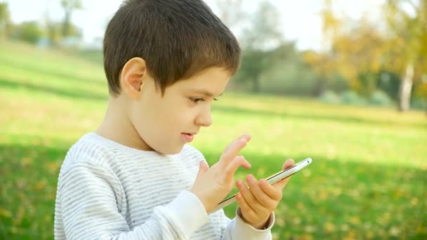 Маленький Ребенок Использует Смартфон Открытом Воздухе — стоковое видео