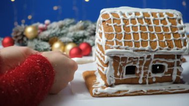 Zencefilli bir Noel evini şekerle süsleme süreci.