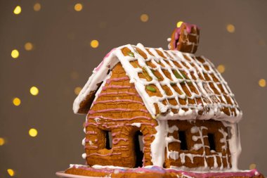 Şekerli kurabiyelerle süslenmiş zencefilli kurabiyeden yapılmış Noel evi..