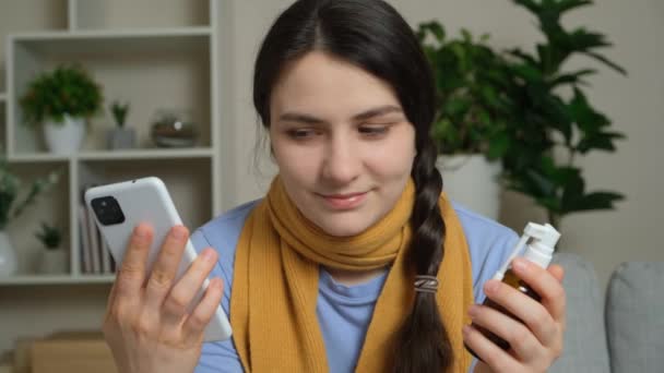 Μια Άρρωστη Γυναίκα Κρατάει Ένα Smartphone Και Ένα Φάρμακο Στα — Αρχείο Βίντεο