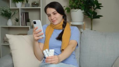 İnternet 'te ilaç kullanımına ilişkin talimatları evde akıllı telefon kullanarak okuyan kadın