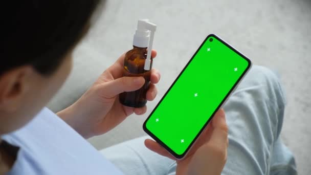 患者の手と薬瓶の緑色のスクリーン クロマ キーが付いているスマートフォン — ストック動画