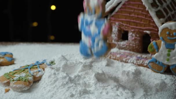男性の形をしたジンジャーブレッドは粉砂糖で作られた雪に落ちる — ストック動画