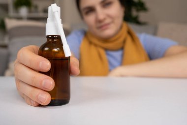 Boğaz ağrısını tedavi etmek ve hastaların elinde öksürmek için bir şişe ilaç.