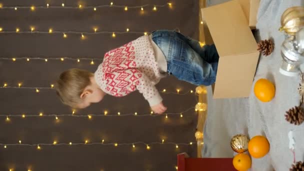 Dwuletni Chłopiec Bawiący Się Kartonowym Pudełkiem Święta Wychodzi Pudełka — Wideo stockowe