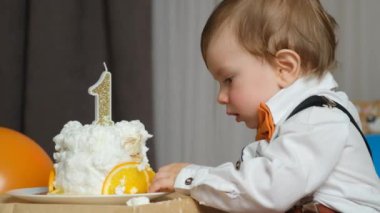 Bir yaşındaki bir çocuk ilk doğum günü pastasını yer. Çocuklar için Sağlıklı Tatlılar