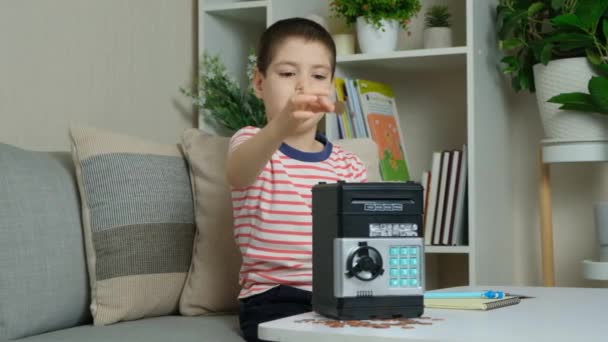 小さな6歳の少年は おもちゃの金庫に入れてお金を貯めました 財政的に子供を文学的に — ストック動画