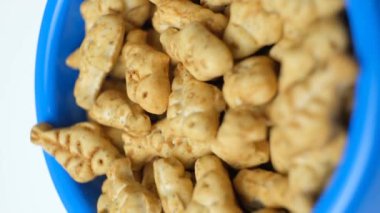 Kediler için bisküviler ve kedi kâsesinde kedi nanesi şeklinde kedi nanesi olan kediler yakın çekimde döner.