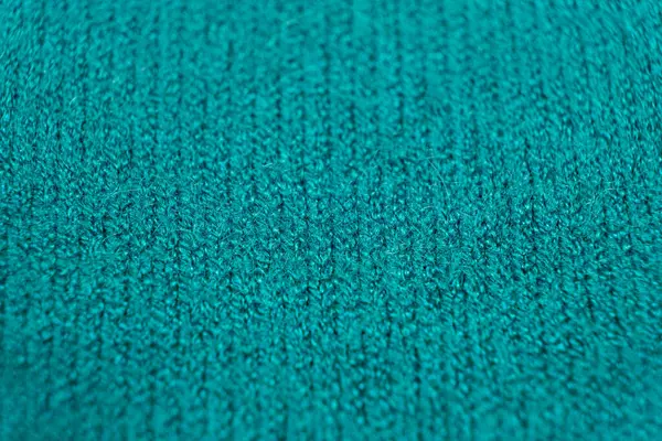 Green soft fabric made of viscose, polyester and nylon. Fabric industry, fabric for sweater, selective focus