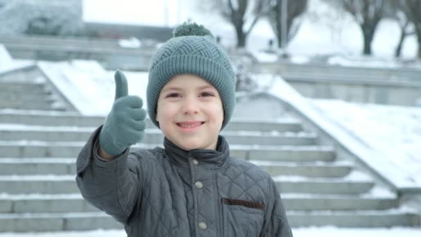 Sześcioletni Chłopiec Pokazuje Kciuki Górę Gest Rąk Super Zimowym Parku — Wideo stockowe