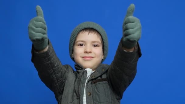 Glædelig Seksårig Dreng Der Smiler Viser Tommelfingre Opad Iført Hat – Stock-video