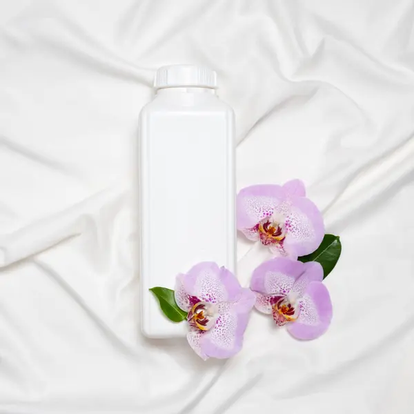 Natural fabric softener on satin fabric with orchid flowers.
